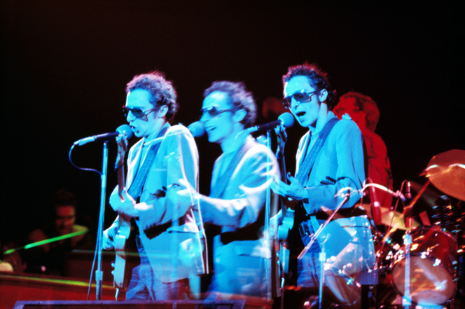 triple exposure of Graham Parker in blue light on stage