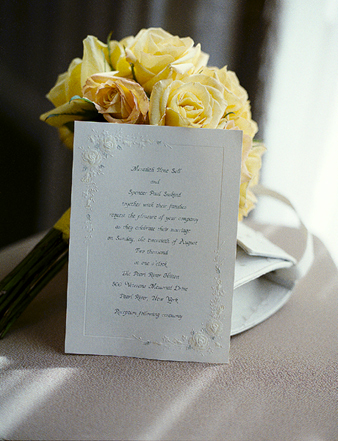 Wedding invitations with yellow roses in background