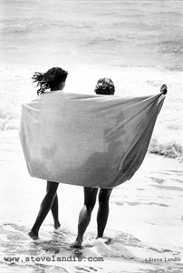two girls walking on the beach wrapped in towel