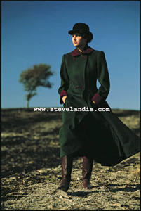 silke in long green coat strutting through burned out wheat field in Tuscany, shot by Steve Landis