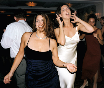 The bride with a girl friend on the dance floor during her wedding reception 